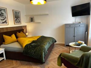 a bedroom with a bed and a tv and a chair at Carl-Schmäcke-Straße 7 in Neuenhagen