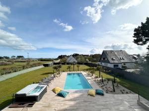 an image of a swimming pool in a backyard at Superbe Villa à 200m de la plage tout confort avec piscine chauffée, couverte et spa in Fouesnant