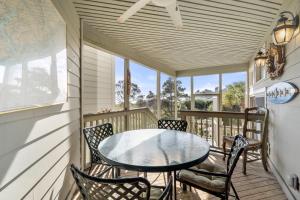 un porche con mesa y sillas en 1107 Duneside Villa by Akers Ellis Rentals, en Kiawah Island