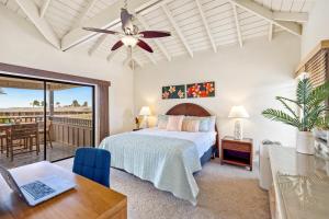a bedroom with a bed and a desk with a laptop at Poipu Sands 221 in Koloa +40 photos