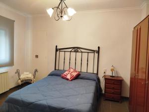 a bedroom with a bed with a pink pillow on it at Casa tío Manolo in Sinarcas