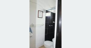 a small bathroom with a toilet and a shower at Bungalow Turrent, a 5 minutos de Playa Mocambo in Veracruz +2 photos