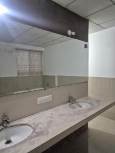a bathroom with two sinks and a large mirror at Elite Stays -Viman Nagar in Pune