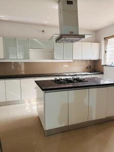 a kitchen with white cabinets and a stove top oven at Elite Stays -Viman Nagar in Pune +27 photos
