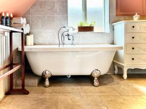 a white bath tub in a bathroom with a window at The Corner House, Shipston-on-Stour in Shipston-on-Stour