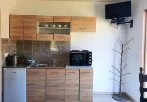 a kitchen with wooden cabinets and a sink and a microwave at The Getaway in Sálakos