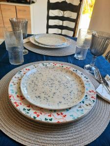 a blue table with plates and forks and glasses at The Getaway in Sálakos
