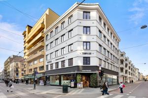 a white building on the corner of a street at Luxury 4-Bedroom Apartment in Oslo's Heart - Walk to Major Attractions in Oslo