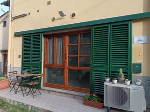 a building with green shutters and a table and a patio at La Corte di Peretola Boutique Apartment in Florence