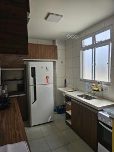 a kitchen with a white refrigerator and a sink at Residencial Marajoara 1 in Belém