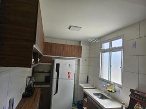 a kitchen with a white refrigerator and a window at Residencial Marajoara 1 in Belém +1 photo