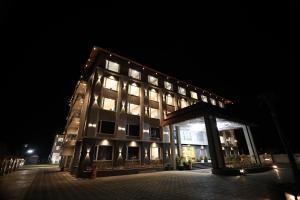 布什格尔Krishna Resort Pushkar的晚上有很多窗户的大楼