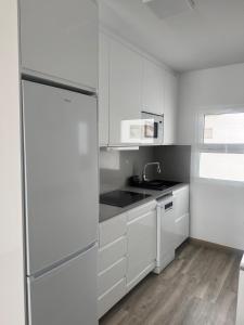 a white kitchen with a sink and a refrigerator at Omayra Beach in Tías +10 photos