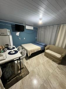 a small room with a bed and a couch at Casa familiar rua 13 maio número 1639 in Rosário do Sul