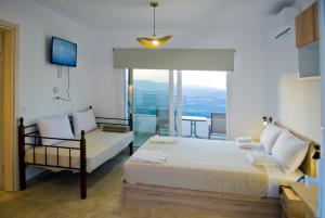 a bedroom with a bed and a couch and a window at Kandania Paradise in Kántanos +58 photos