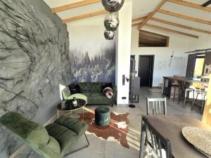 ein Wohnzimmer mit einer grünen Couch und einer Steinwand in der Unterkunft Hunsrücker Tiny Ferien R in Hottenbach