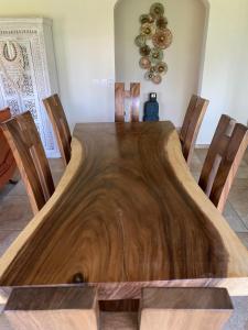 a wooden table in a room with chairs around it at Chambre d'Hôte Créole in Le Tampon
