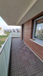a balcony with a wooden floor and a window at Apartament Bianco - Aquapark in Rumia