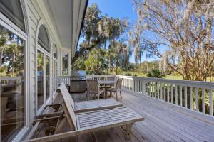 un portico con panchina e tavolo sopra di 115 Bufflehead Drive by Akers Ellis Rentals a Kiawah Island