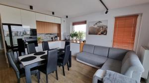 a kitchen and living room with a couch and a table at Apartament Bianco - Aquapark in Rumia