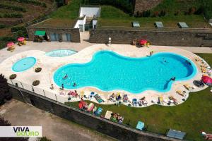 an overhead view of a swimming pool with people sitting around it at Casa de campo do Rojão do Meio in Mesão Frio
