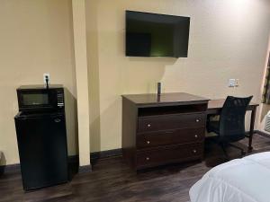 a hotel room with a desk and a television at Red Lion Inn & Suites IAH Airport East in Humble
