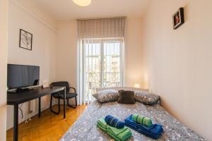 a bedroom with a bed with a desk and a television at Flexible SelfCheckIns 47 - Zagreb - Two Loggia - New - 3 Bedrooms - 2 WC in Zagreb