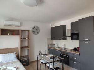 a kitchen with a table and a clock on the wall at Vera Alloggio Alessandria nr2 in Alessandria