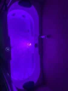 Baño púrpura con aseo con luz púrpura en Balneo Clim Terrasse et Parking Relaxation Guarantie, en Fréjus