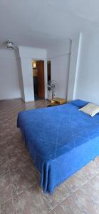 ein blaues Bett mit blauer Decke in einem Zimmer in der Unterkunft La Martina in Villa Carlos Paz