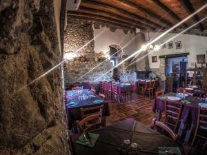 a dining room with tables and chairs and a stone wall at Tenuta TerraRossa in Rossano