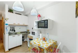 a small kitchen with a table and a microwave at La Lajilla Arguineguin in Arguineguín