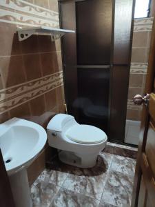 a bathroom with a toilet and a sink and a shower at Hostal Río Escondido Santa Fe in Santa Fé