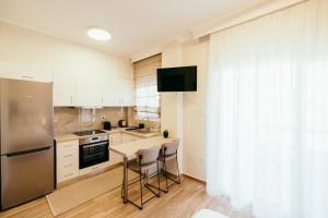 a kitchen with a refrigerator and a table with stools at Cozy apartment HouseNest in Serres
