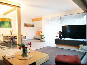 ザンクト・ヴォルフガングにあるSEE & THE CITY apartmentsのリビングルーム(大画面薄型テレビ付)