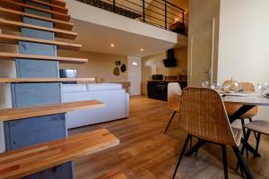 a living room with a white couch and a table at Duplex avec terrasse proche Pérouges Meximieux CNPE BUGEY in Faramans