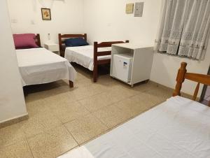 a room with two beds and a table and chairs at Pousada Sabiá in Cuiabá