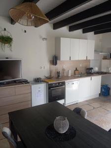 a kitchen with white cabinets and a black table with a table sidx sidx sidx at La tanière de Lise in Puyravault