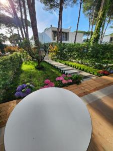 a white table in front of a garden with flowers at SanPietro Relax Apartment in Durrës