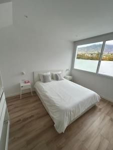 a white bedroom with a large bed and a window at Urban Loft in Los Llanos de Aridane