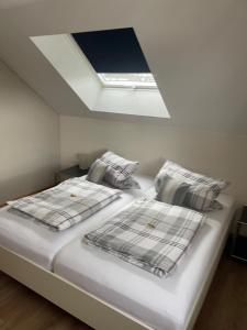 a bedroom with a bed with two pillows and a ceiling at Eifelbrise in Simmerath
