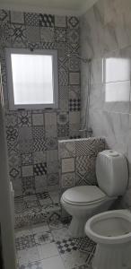 a bathroom with a toilet and a window at Mini Loft in Tandil