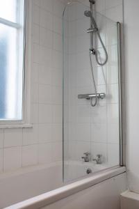 a shower with a glass door next to a bath tub at 6 BR 4 Bath Central Worcester Sleeps 12 in Worcester