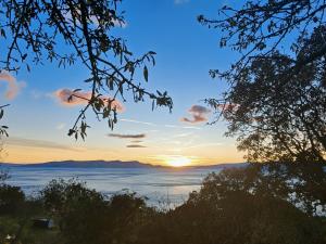 a sunset over the water with mountains in the background at Apartment Biondic in Senj