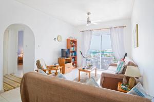 a living room with a couch and a window at King's Palace Apartment in Paphos