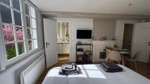 een slaapkamer met een bed en een kamer met een tafel bij Appartement rénové 250m du port - classé 3 étoiles in Honfleur