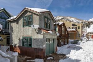 ein Haus mit grüner Tür im Schnee in der Unterkunft Heritage House by Exceptional Stays in Telluride