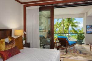 una camera con letto e sedia e un balcone di Beautifully Decorated Ocean Front 3 Bedroom Den, 35 Bath Montage Kapalua Grand Residence Sleeps 8 a Kapalua Altre 32 foto