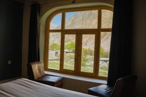 Un dormitorio con una ventana con vista a la montaña. en North Vibe Resort Hunza, en Hunza