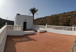 a balcony of a house with a palm tree at Chalet Barranco Hondo Agaete in Agaete